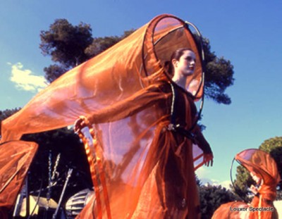 Interprète dans un costume orange translucide en plein air