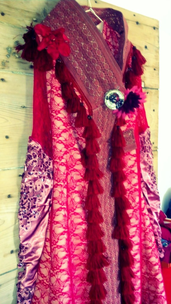 Costume textile rouge brodé présenté sur mannequin